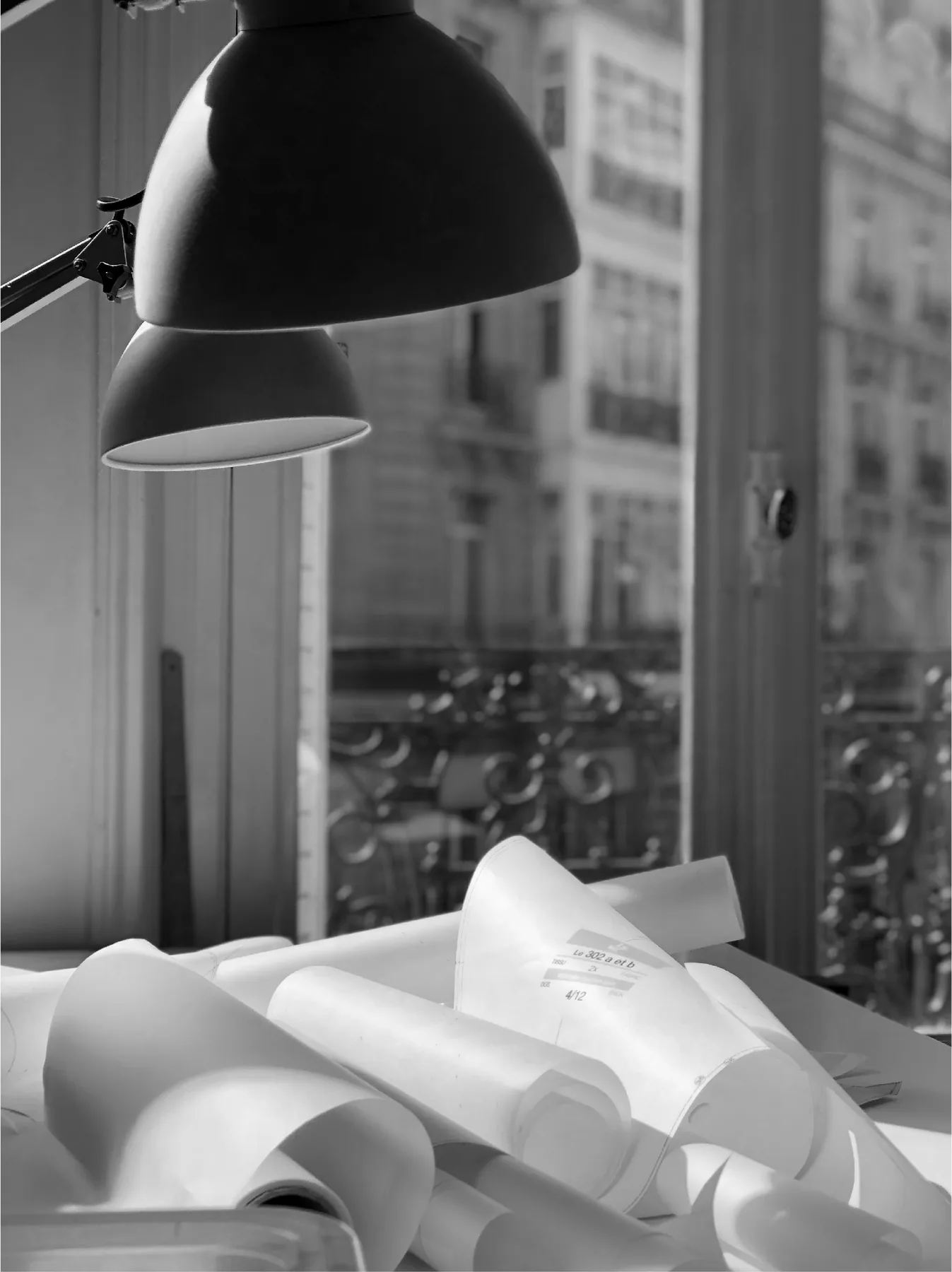 Lampes d’architecte au-dessus de rouleaux de patrons, à l’atelier